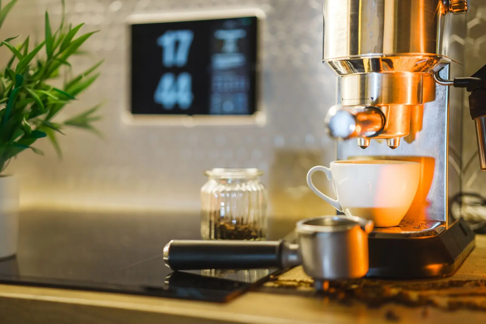 Une machine expresso sur un plan de travail de cuisine, une tasse posée dessous, le café en train de couler